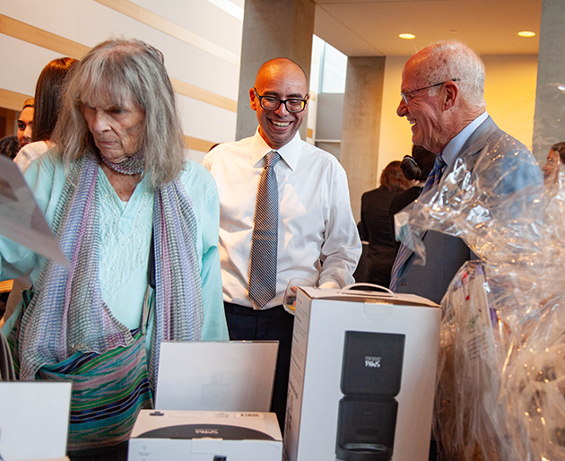People smiling and looking at Penthouse Paws products. 